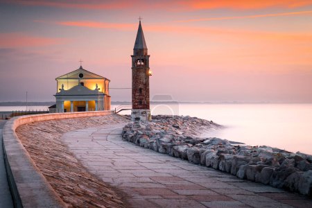 Photo for Lighthouse in Caorle, Italy. Sunrise at Caorle. Caorle is an Italian town in the metropolitan city of Venice. Madonna dell'Angelo Church. - Royalty Free Image