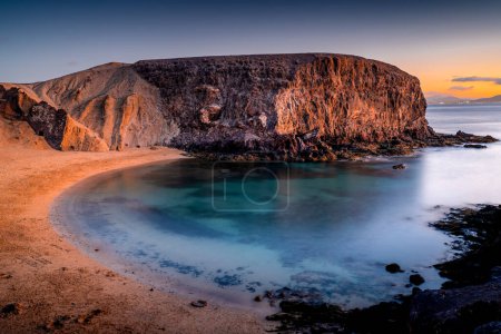 Foto de Playa de Papagayo después de la puesta del sol, la playa más hermosa de la isla de Lanzarote. Bahía-playa en España. - Imagen libre de derechos