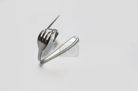 Foto de Un tenedor en posición de imitar una mano haciendo cosas malas - Imagen libre de derechos