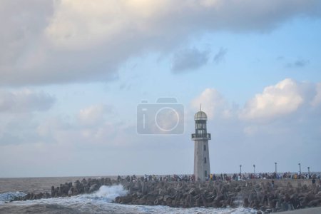Téléchargez les photos : Phare et brise-lames sur le front de mer de damietta, Egypte sur un crépuscule brumeux et nuageux - en image libre de droit