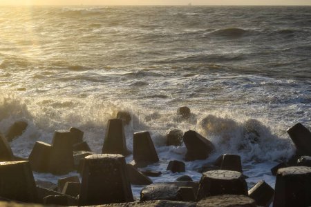 Téléchargez les photos : Une vue sur les vagues océaniques interceptées par un brise-vagues à la plage de damietta en Egypte sur un magnifique coucher de soleil - en image libre de droit