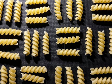 Fusilli pasta as background image. Image texture spiral macaroni. Top view. Italian pasta.