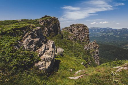 Foto de Babin Zub roca de la montaña Stara Planina, popular destino de viaje en Serbia. Paisaje de la montaña vieja en el fondo de colinas verdes, laderas boscosas y bosque de coníferas en el día soleado de verano. - Imagen libre de derechos