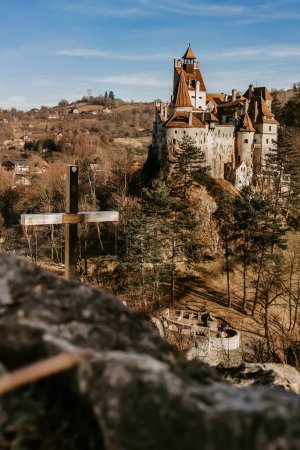 Photo for Bran castle or Count Dracula Castle view from viewpoint on hill with cross. Medieval fortress in Romania, popular travel destination and touristic landmark. Gothic vampire castle in haunted forest. - Royalty Free Image