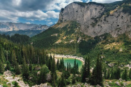 Foto de Lago Jablan en el Parque Nacional Durmitor, vista desde una roca. Lago glacial rodeado de bosque de coníferas. Paisaje de montaña de verano con lago - atracción natural y destino de senderismo de los Alpes Dináricos. - Imagen libre de derechos