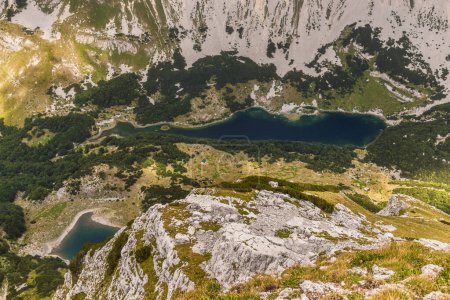 Téléchargez les photos : Lacs Skrcko entourés de hautes montagnes, vue depuis le sommet de la montagne Prutas. Paysage des hautes terres dans le parc national de Durmitor, Monténégro. Vue des lacs glaciaires montagneux des Alpes dinariques d'en haut. - en image libre de droit