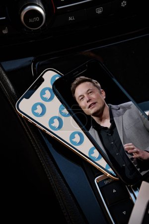 Foto de CHENNAI, INDIA - MARCH21, 2023: Muchos logos de la red social Twitter en la pantalla del teléfono inteligente y la foto de Elon Musk en otro fondo de pantalla del teléfono inteligente. - Imagen libre de derechos