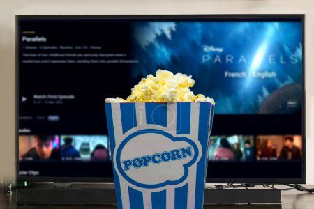 Photo for Parallels tv series displayed television with popcorn in front. entertainment with movies concept. illustrative editorial. - Royalty Free Image