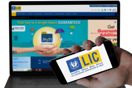 Photo for LIC Bank logo in mobile screen and their blurred website displayed in Laptop screen. editorial image. - Royalty Free Image