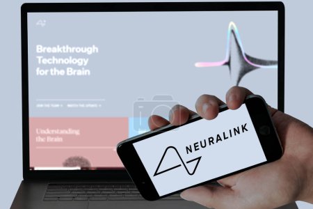 Photo for Neuralink company logo in mobile screen and their blurred website displayed in Laptop screen. editorial image. - Royalty Free Image