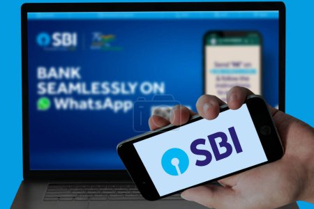 Téléchargez les photos : SBI Bank logo dans l'écran mobile et leur site Web flou affiché dans l'écran de l'ordinateur portable. image éditoriale. - en image libre de droit