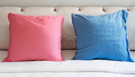 Photo for Pink and blue color two pillows on soft white bed. copy space image. - Royalty Free Image