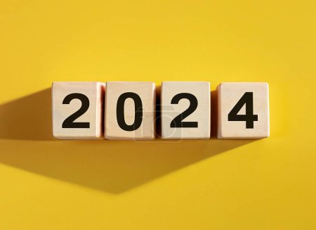 Téléchargez les photos : 2024 affiché sur des blocs de lettres en bois isolés sur fond jaune - en image libre de droit