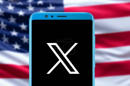 Foto de Logo de Twitter X en pantalla móvil y bandera de EE.UU. imagen borrosa en el fondo. - Imagen libre de derechos