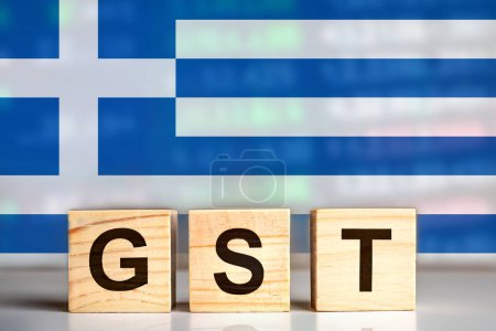 Foto de GST se muestra en bloques de letras de madera con fondo de bandera de Grecia. concepto de impuestos. diseño de ilustración. - Imagen libre de derechos