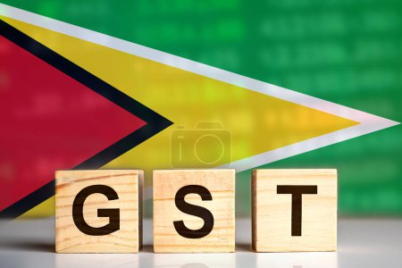 GST displayed on wooden letter blocks with Guyana flag background. tax concept. illustration design