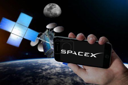 Foto de Logotipo SpaceX en la celebración de la pantalla móvil y Hughes Júpiter 3 fondo de desenfoque por satélite. - Imagen libre de derechos