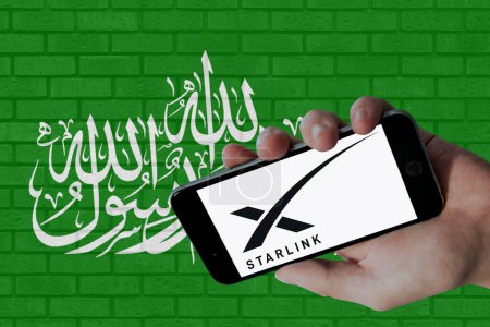 Téléchargez les photos : Logo Starlink affiché sur écran mobile et drapeau du Hamas avec fond de texture murale. - en image libre de droit