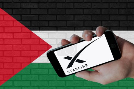 Téléchargez les photos : Logo Starlink affiché sur écran mobile et drapeau palestinien avec fond de texture murale. - en image libre de droit