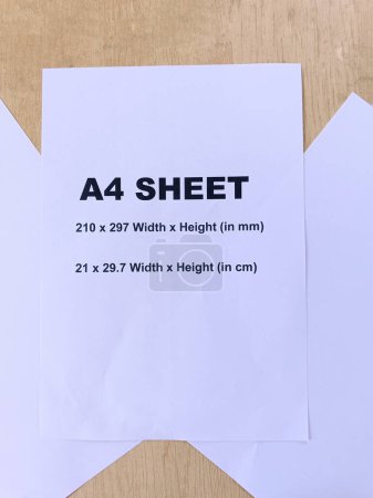 A4 sheet text and size printed on sheet with another two plain sheets in decorative way. isolated on desk background.