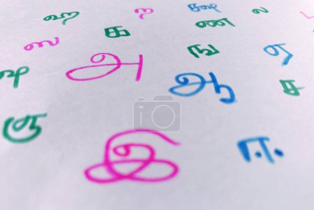 Handgeschriebene Bunt skizzierte zufällige tamilische Buchstaben in Blatt. in Übersetzung A, Aa, E. Nahaufnahme.