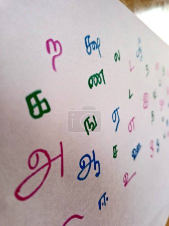 Hand written Colorful sketched Random Tamil language letters in sheet. in translation A, Aa, E. closeup image.