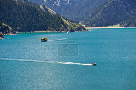 Photo for The beautiful landscape of Tianchi Lake in Tianshan Mountains, Xinjiang, with snow-capped mountains in the distance, and the vast and green Tianhu Lake in front of you, cruise ships on the lake, tourists like to linger on the beautiful trails - Royalty Free Image