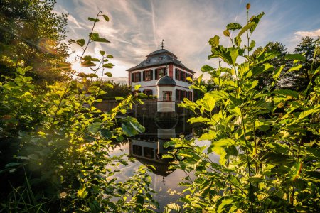 Foto de Vista histórica, castillo amarrado al atardecer, reflejo en el estanque, Klein-Welzheim, Seligenstadt, Hesse, Alemania - Imagen libre de derechos