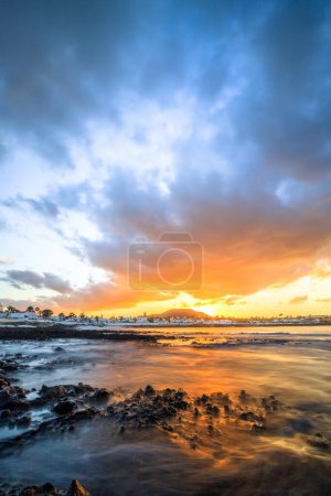 Foto de Puesta de sol en Playa Vista Lobos, larga exposición al mar, playa de lava Corralejo, Islas Canarias, España - Imagen libre de derechos
