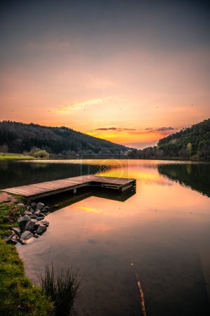 Photo for One of the most beautiful sunsets i have ever seen, a calm reservoir in a valley, green and a forest in the area. the sun sets beautifully in the lake and everything is reflected in the water - Royalty Free Image