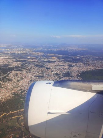 Téléchargez les photos : Vue de la fenêtre de l'avion vers la ville de Lisbonne et le Portugal. Ciel bleu clair, moteur et aile de l'avion. Photo de haute qualité - en image libre de droit