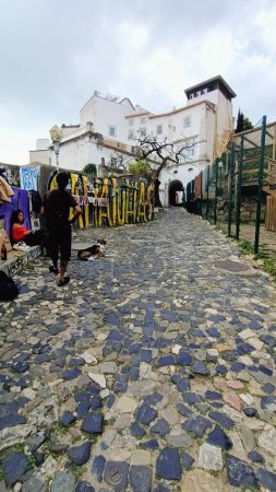 Téléchargez les photos : Une ruelle étroite à Lisbonne où les gens marchent. Photo de haute qualité - en image libre de droit