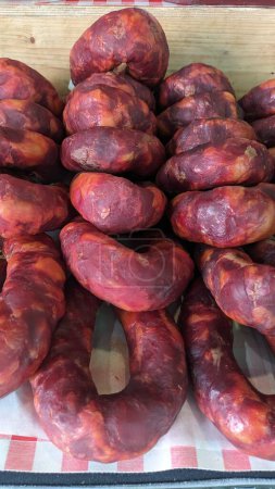 Téléchargez les photos : Saucisse salée crue naturelle à base de viande avec des épices empilées les unes sur les autres à la foire de Lisbonne - en image libre de droit
