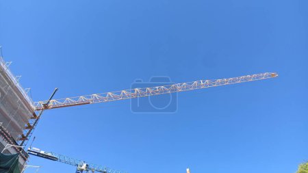 Téléchargez les photos : Grue de construction haute avec un long boom sur ciel bleu à Lisbonne - en image libre de droit