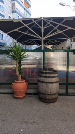Téléchargez les photos : Deux grandes cruches d'argile dans lesquelles poussent des plantes et un tonneau de bois au milieu - en image libre de droit