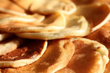 A closeup image of a stack of pancakes, a popular dish made with ingredients like flour, eggs, and milk. A staple food in many cuisines, commonly served as a breakfast or brunch option