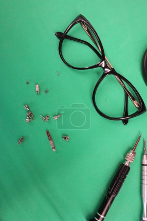 Photo for Small screwdrivers, eyeglasses and eyeglass screws on the masters desk photo - Royalty Free Image