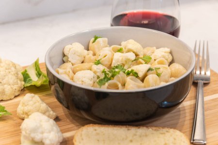 Photo for Pasta with cauliflower and glass of wine on table - Royalty Free Image