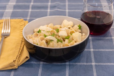 Téléchargez les photos : Pâtes avec chou-fleur et verre de vin sur la table - en image libre de droit