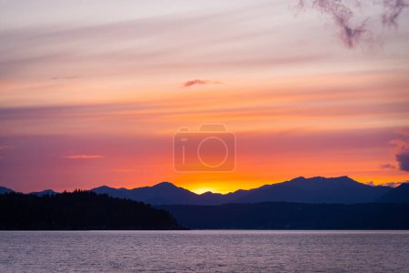 Téléchargez les photos : Vue panoramique sur le lac avec des montagnes silhouette arrière-plan, heure du coucher du soleil - en image libre de droit
