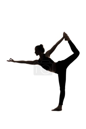 Téléchargez les photos : Une silhouette d'une femme faisant du yoga asana sur fond blanc. Photo de haute qualité - en image libre de droit
