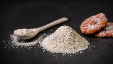 Foto de Especias para recetas. Azúcar vienés. Una cuchara y una pila de azúcar, sal o harina. Dulces. Especia molida. Foto de alta calidad - Imagen libre de derechos