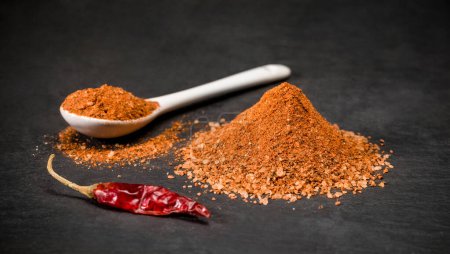 Foto de Especias de chile rojo para recetas. Una cuchara y un montón de pimiento picante. Especia molida. Foto de alta calidad - Imagen libre de derechos