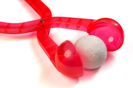Téléchargez les photos : Fabricant de boules de neige en plastique transparent rouge pour les jeux d'hiver et d'hiver pendant les vacances avec une boule de neige. - en image libre de droit