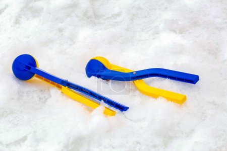 Téléchargez les photos : Fabricant de boules de neige en plastique jaune et bleu pour s'amuser en hiver pendant les vacances sur neige. - en image libre de droit