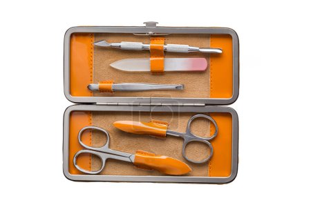 Téléchargez les photos : Ensemble d'instruments et d'outils de manucure en acier dans un étui en cuir orange isolé sur fond blanc. - en image libre de droit