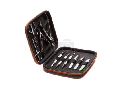Foto de Conjunto de instrumentos y herramientas de manicura de acero en estuche de cuero naranja aislado sobre fondo blanco. - Imagen libre de derechos