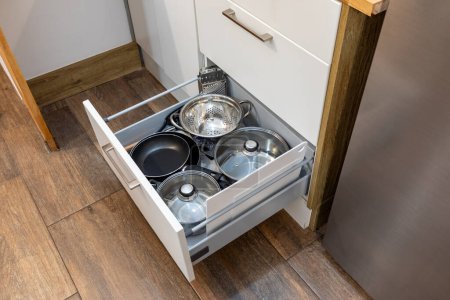 Kitchen drawer organizer, utensil holder with set of pans, cookware, casserole, furniture details.