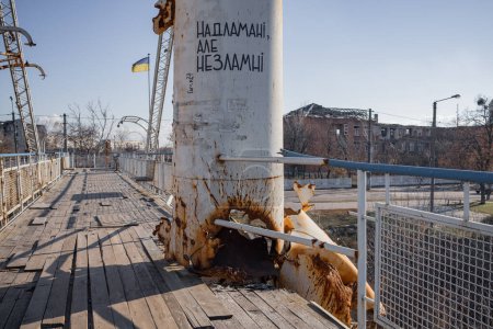 Photo for Izyum, Ukraine. - November 10, 2023: Pedestrian bridge across the Siverskyi Donets River. Destroyed in the spring of 2022. People wrote on the pillar "Fragile, but unbreakable" - Royalty Free Image
