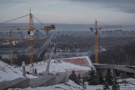 Téléchargez les photos : Kiev, Ukraine. 28 novembre 2023 : Construction avec grues de chantier en cours près de la rivière Dnipro - en image libre de droit